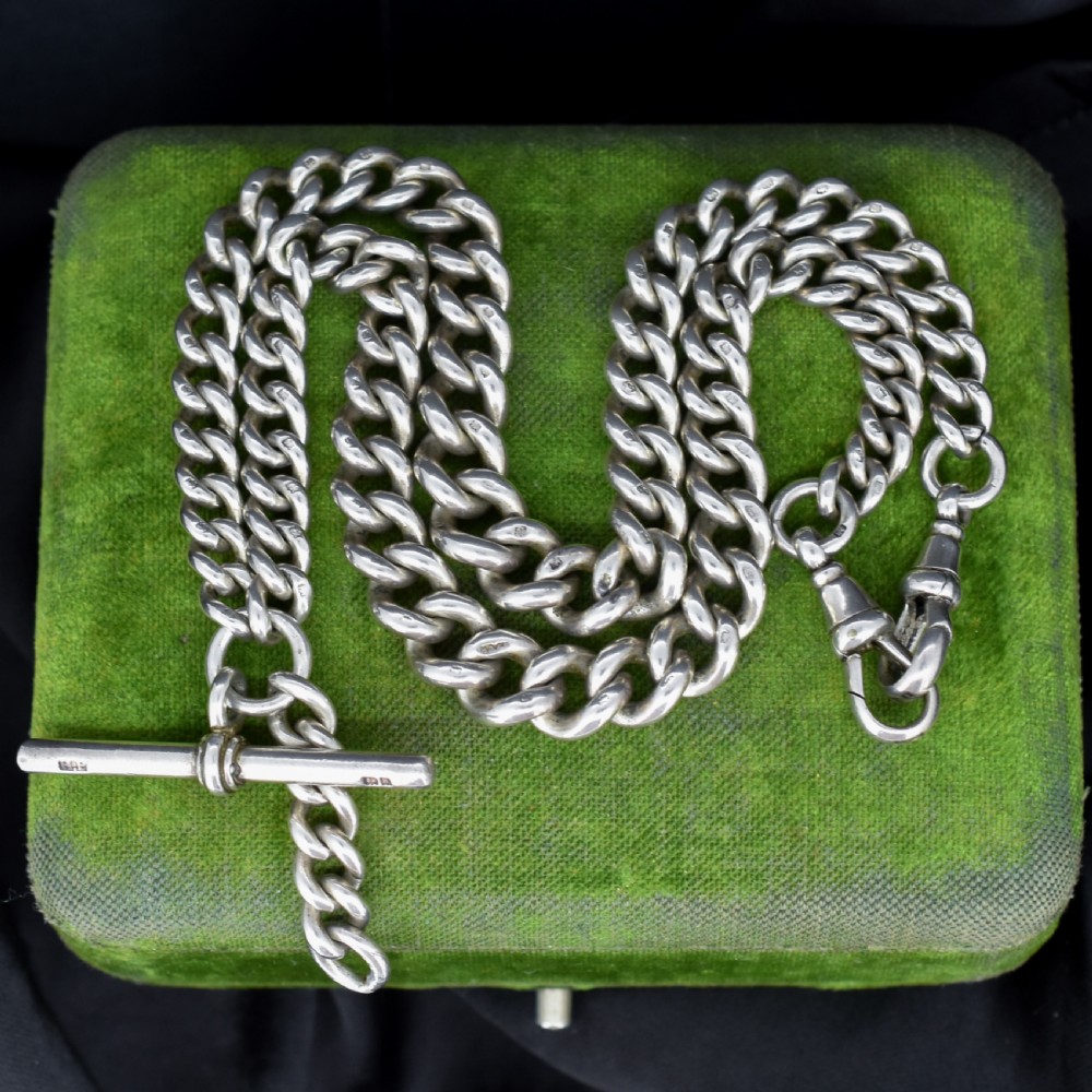 A sterling silver curb link Albert watch chain featuring a T-bar attachment and a swivel clip.