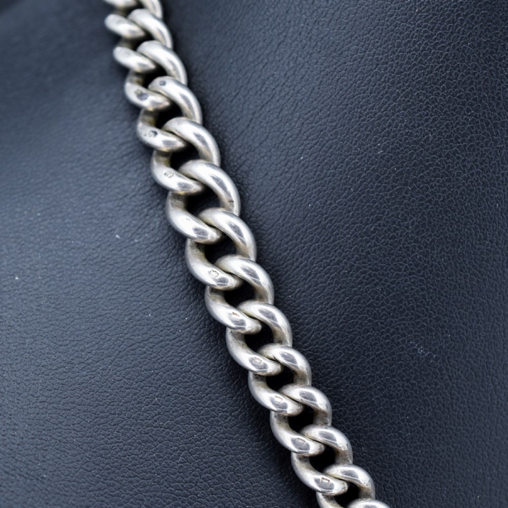 A sterling silver curb link Albert watch chain featuring a T-bar attachment and a swivel clip. View IV