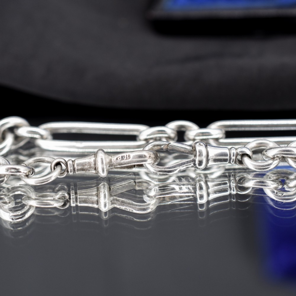 An antique sterling silver trombone link pocket watch chain with a T-bar attachment and dog clip fastener. View V