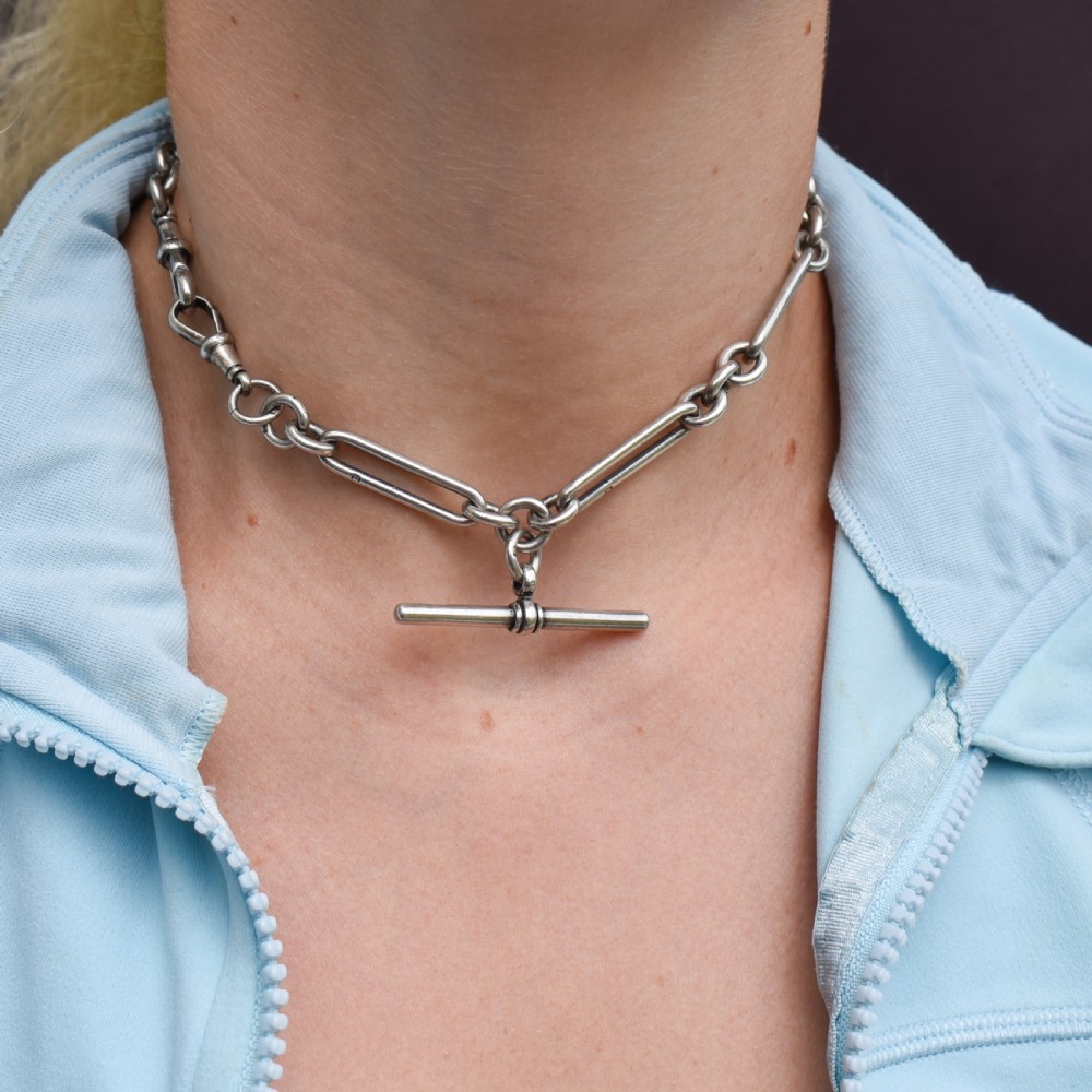 An antique sterling silver trombone link pocket watch chain with a T-bar attachment and dog clip fastener. View VIII