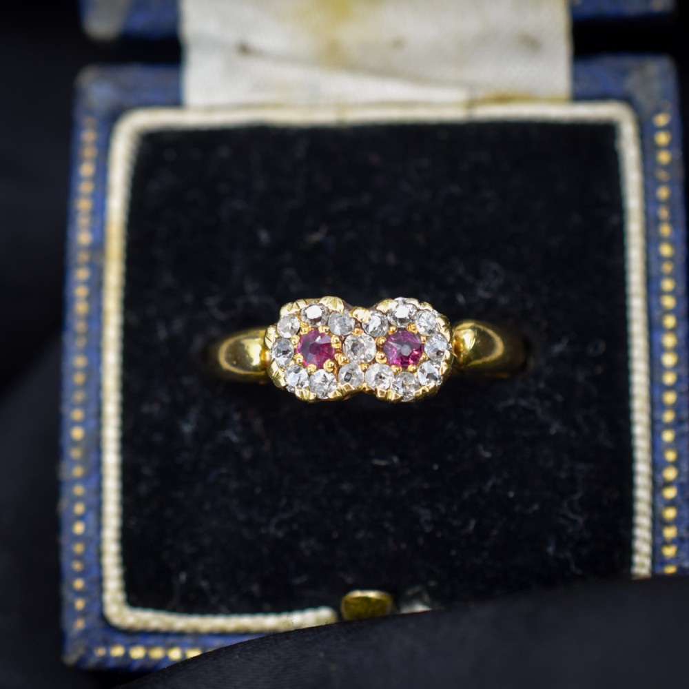 An antique 18ct yellow gold ring featuring a figure-of-eight double cluster set with two central pinkish-red rubies surrounded by small diamonds. View III