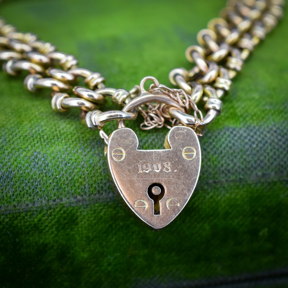 An antique 15ct yellow gold gate link bracelet fitted with an engraved heart padlock clasp and a safety chain. View II