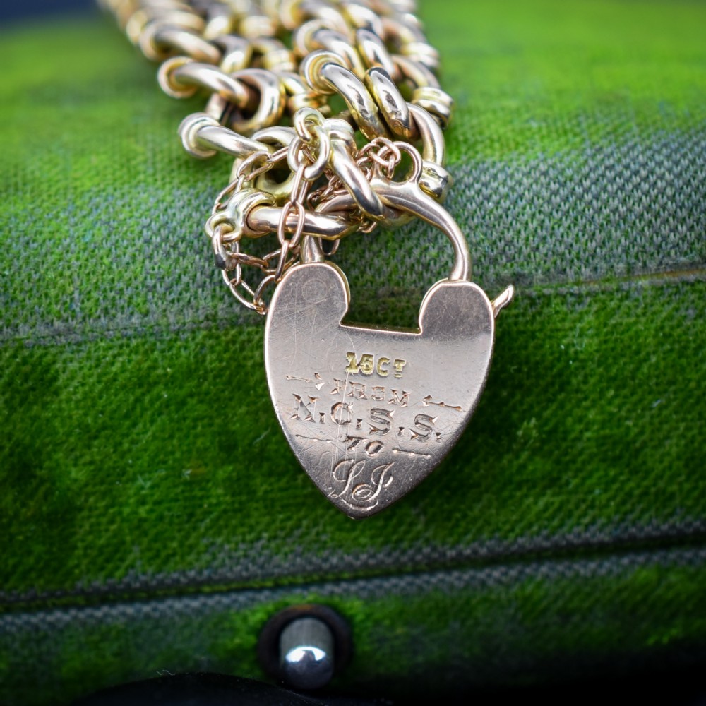 An antique 15ct yellow gold gate link bracelet fitted with an engraved heart padlock clasp and a safety chain. View III