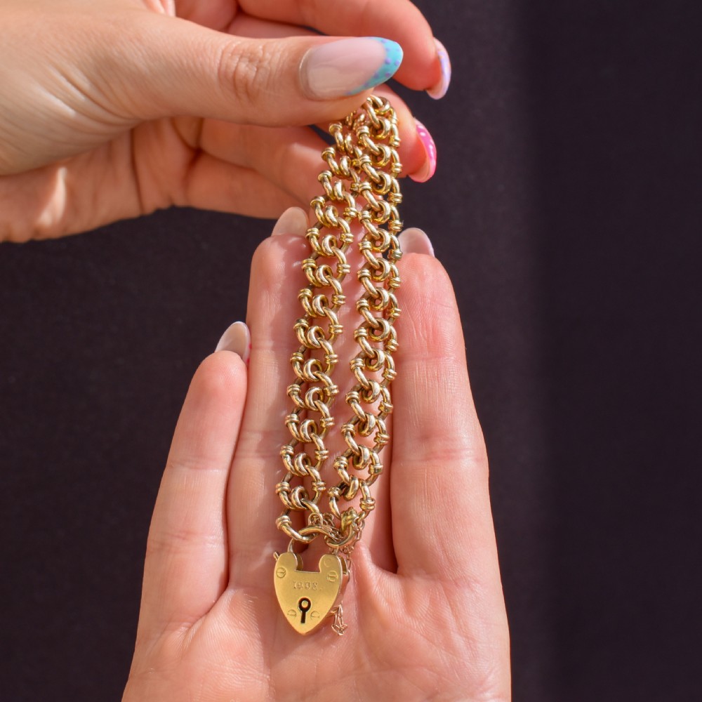 An antique 15ct yellow gold gate link bracelet fitted with an engraved heart padlock clasp and a safety chain. View VII