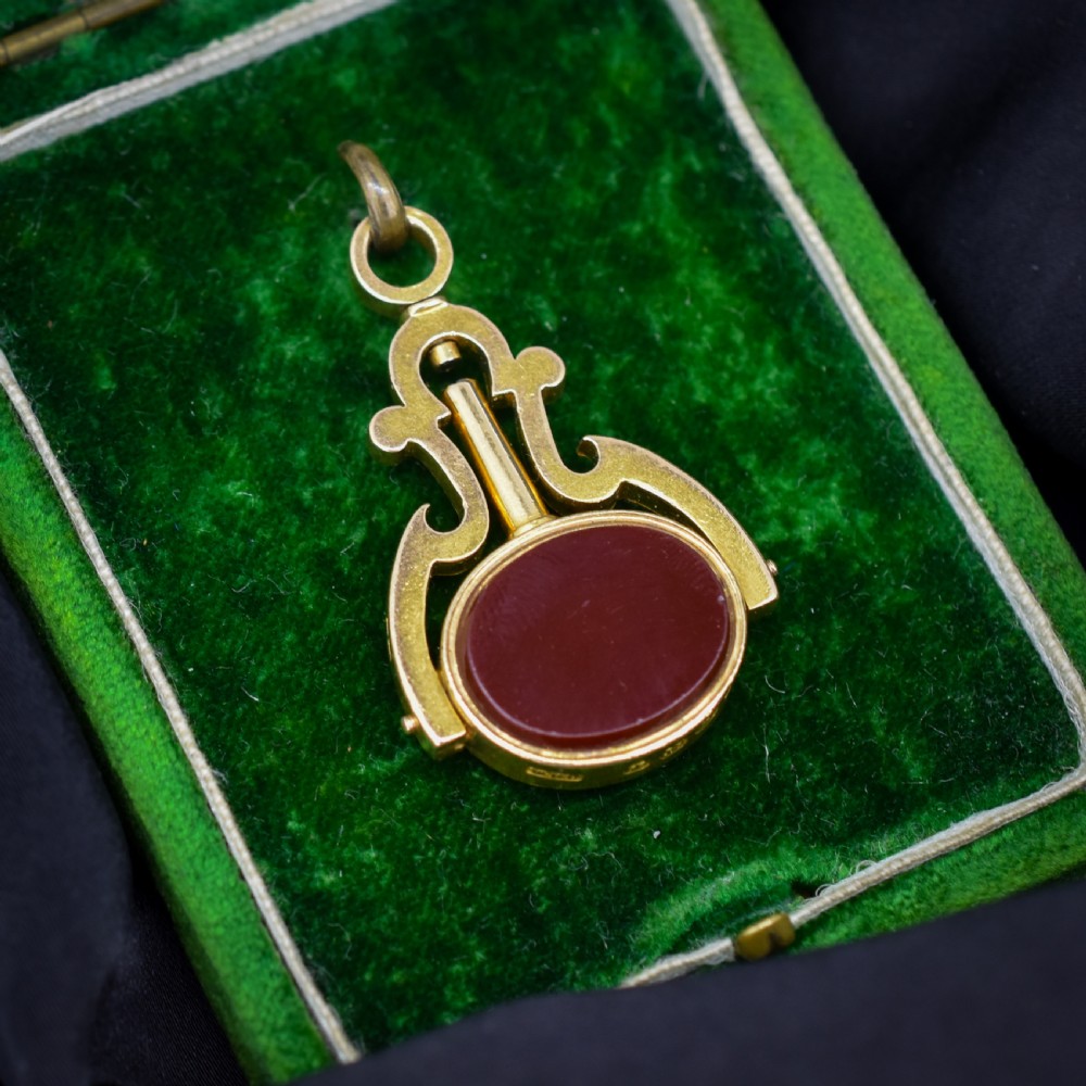 An antique Victorian 18ct gold spinning fob watch key pendant featuring a swivel-set oval dark green bloodstone with red flecks held within a scrolled mount. View II