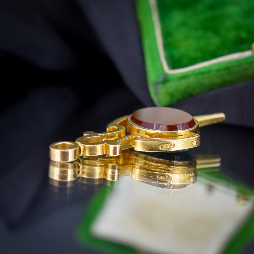 An antique Victorian 18ct gold spinning fob watch key pendant featuring a swivel-set oval dark green bloodstone with red flecks held within a scrolled mount. View V