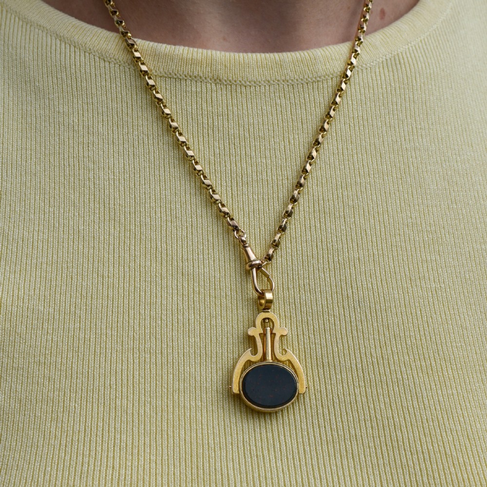 An antique Victorian 18ct gold spinning fob watch key pendant featuring a swivel-set oval dark green bloodstone with red flecks held within a scrolled mount. View X