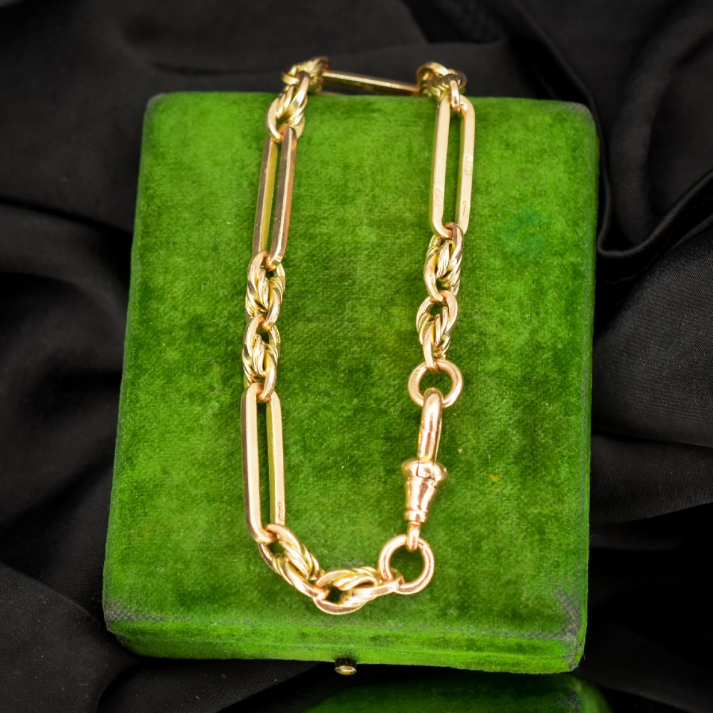 An antique 9ct yellow gold link bracelet composed of alternating trombone links and twisted love knots with a dog clip clasp. View V