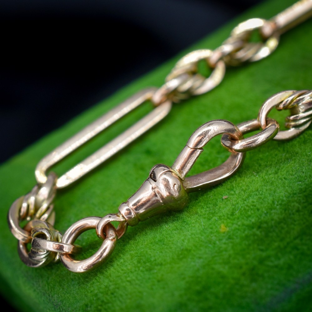 An antique 9ct yellow gold link bracelet composed of alternating trombone links and twisted love knots with a dog clip clasp. View VIII