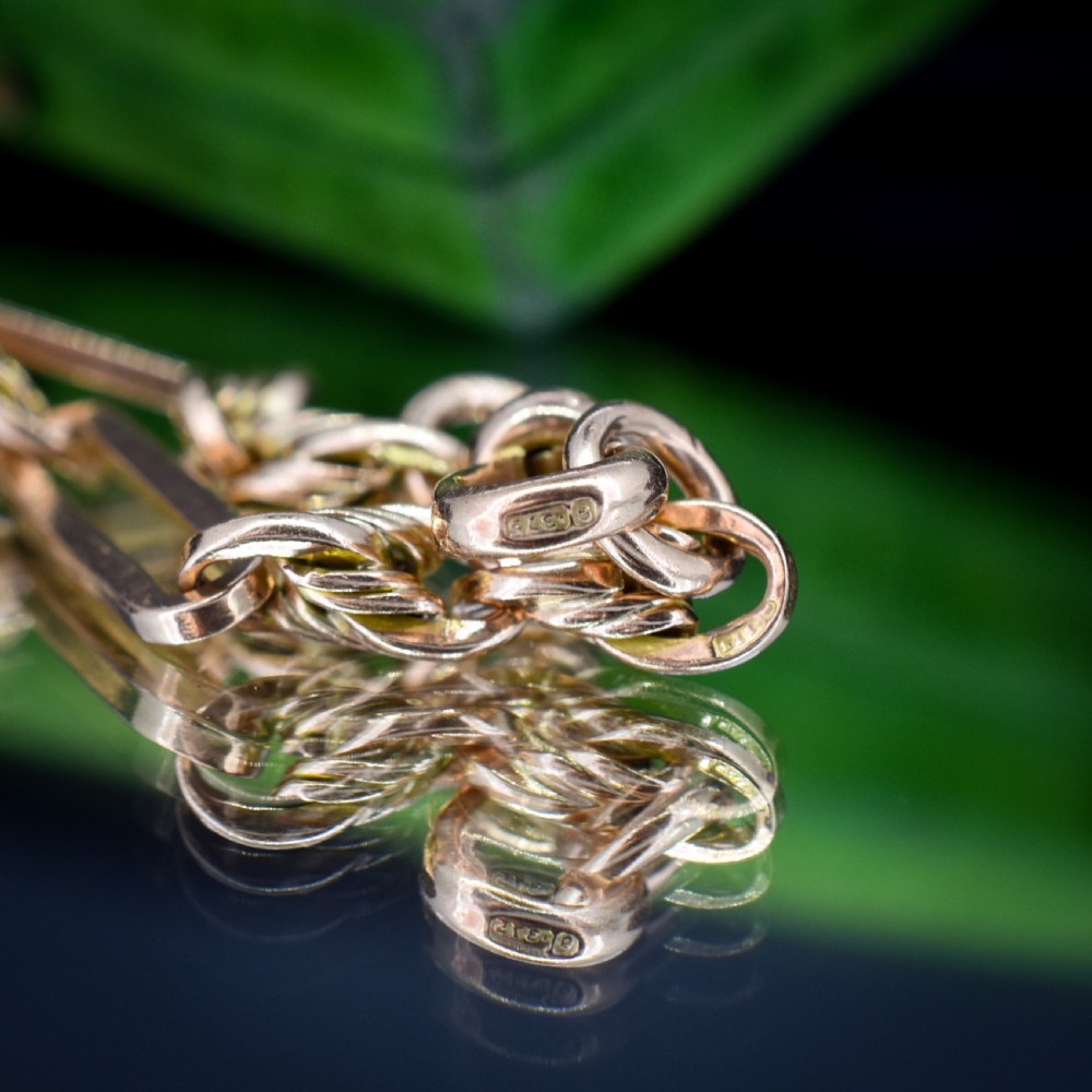 An antique 9ct yellow gold link bracelet composed of alternating trombone links and twisted love knots with a dog clip clasp. View XI