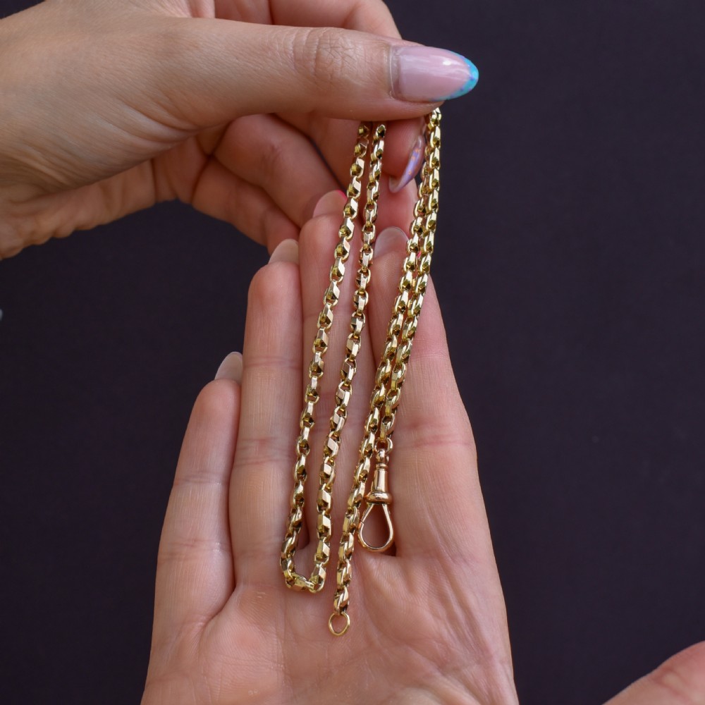 An antique 9ct yellow gold tulip link chain necklace featuring an integrated swivel dog clip clasp. View III