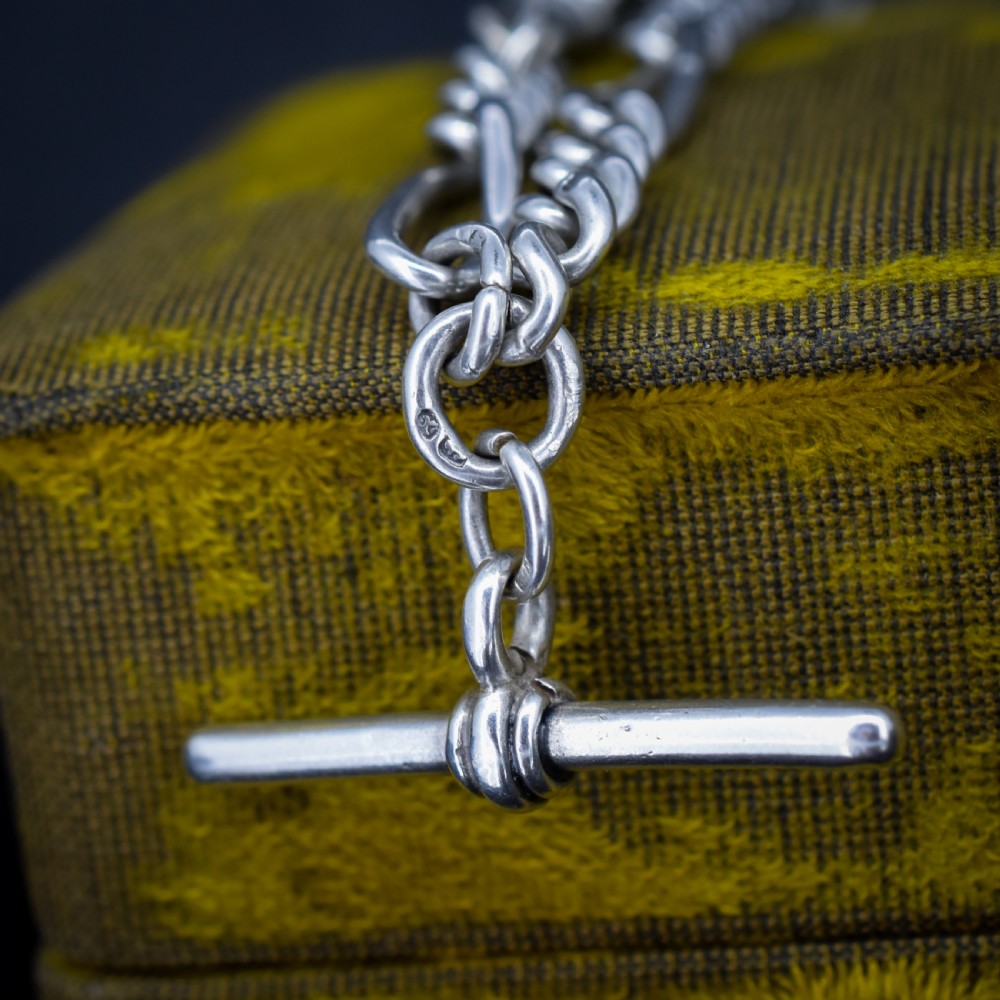 An antique sterling silver double Albert watch chain featuring Figaro style links, a central T-bar, and dual swivel clasps. View IV