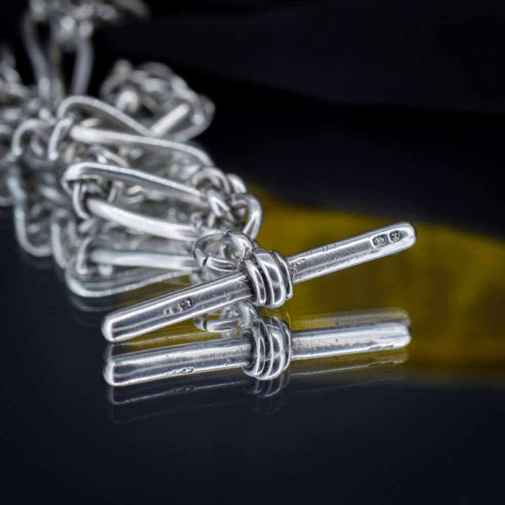 An antique sterling silver double Albert watch chain featuring Figaro style links, a central T-bar, and dual swivel clasps. View VIII