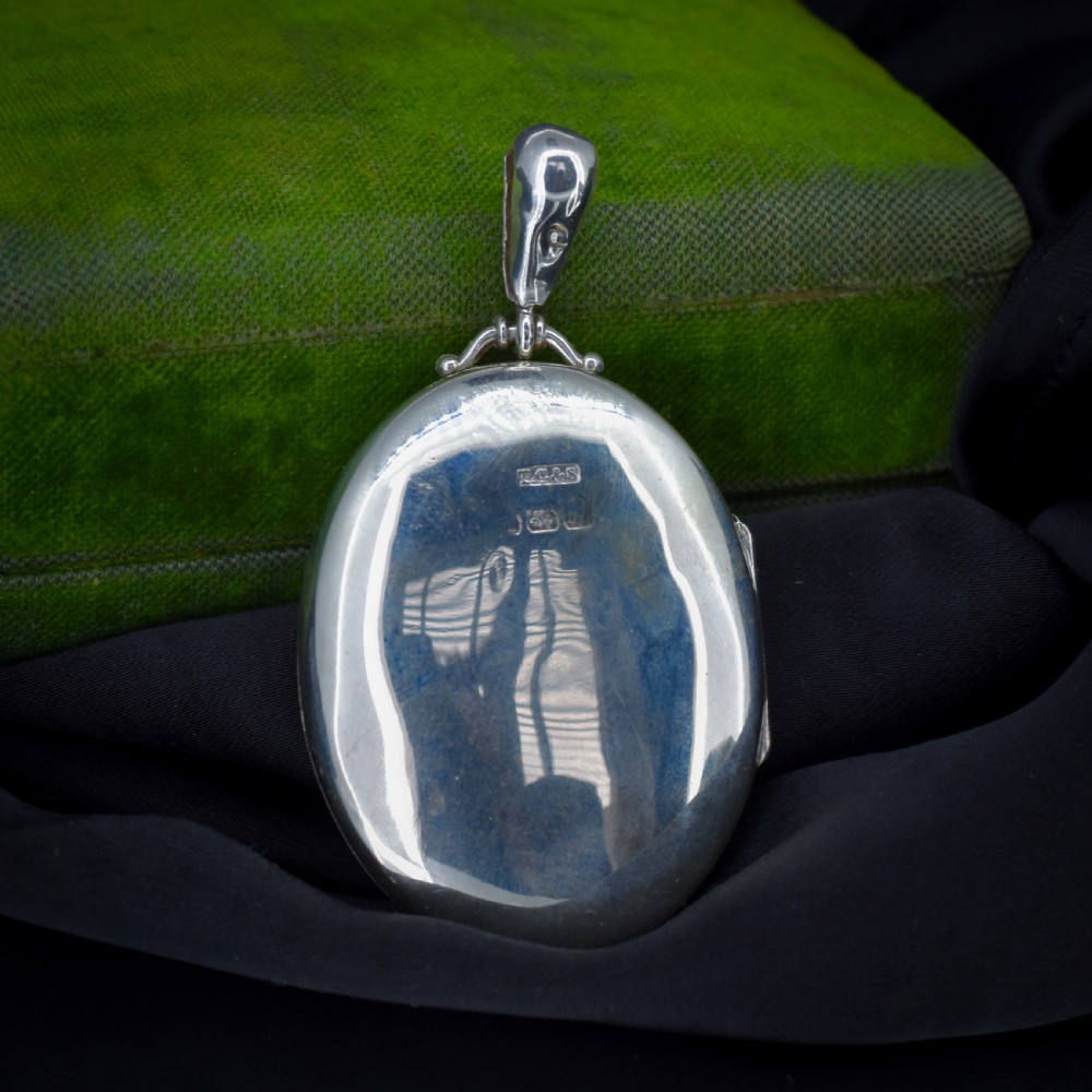 A Victorian oval sterling silver photo locket featuring a central hand-engraved ivy leaf motif framed by an anthemion border. View III
