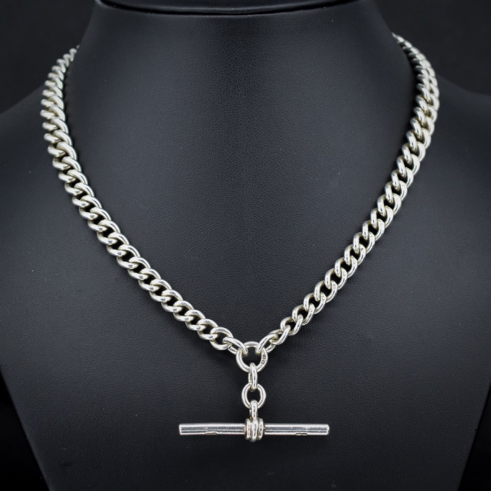 An antique sterling silver heavy curb link Albert watch chain featuring a T-bar and swivel clasp, displayed flat. View II