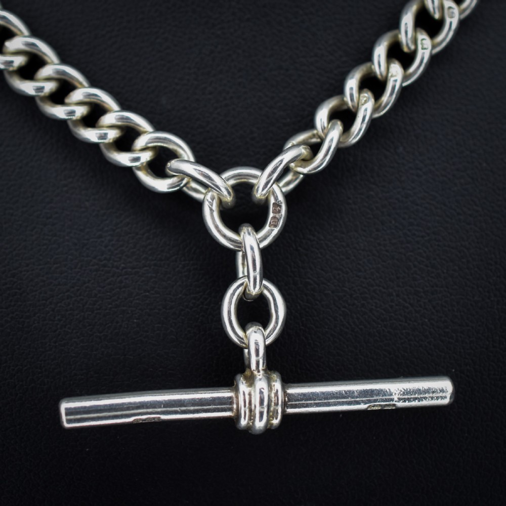 An antique sterling silver heavy curb link Albert watch chain featuring a T-bar and swivel clasp, displayed flat. View III