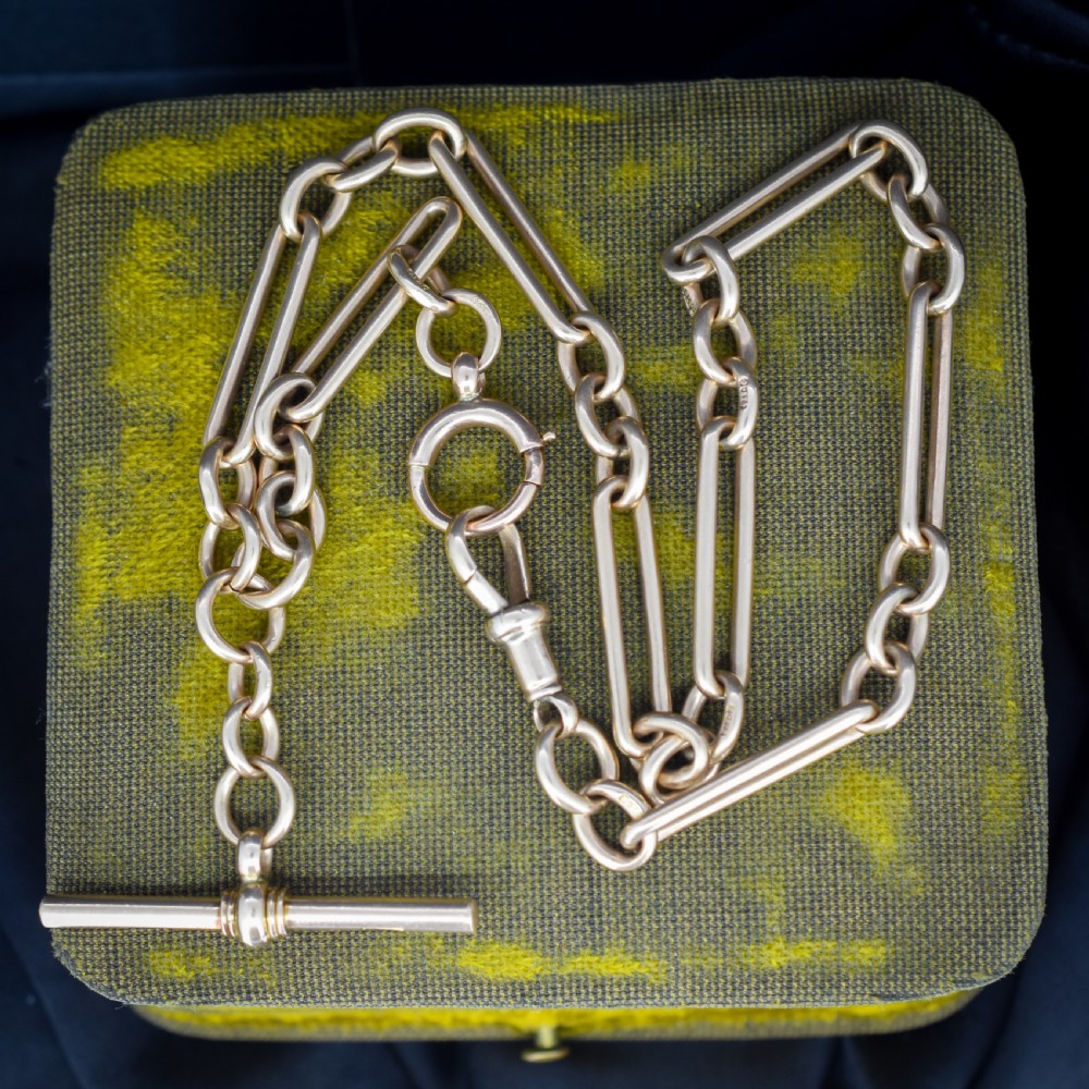An antique 9ct gold trombone link Albert chain necklace with a T-bar, dog clip, and bolt ring clasp.