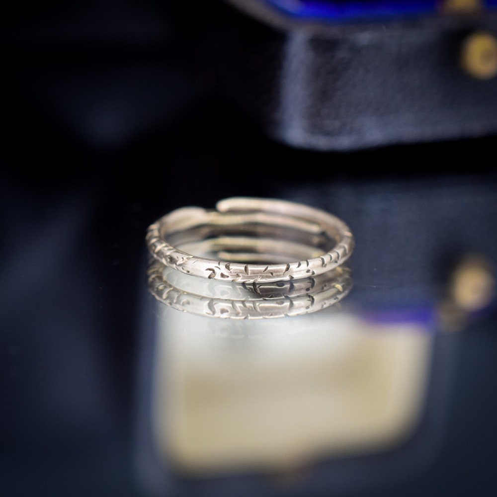An antique 9ct yellow gold split ring measuring 17mm with hand-engraved notch details around the outer circumference. View III
