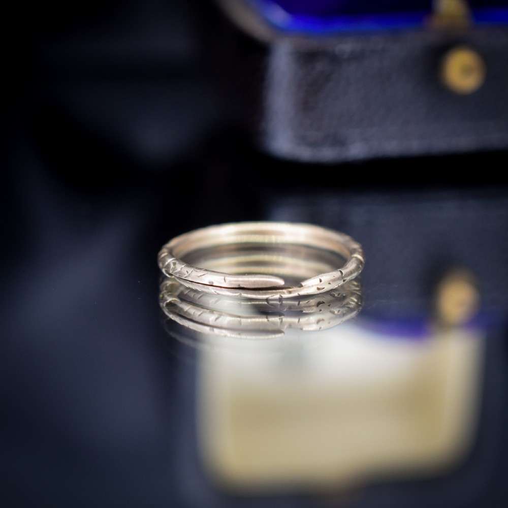 An antique 9ct yellow gold split ring measuring 17mm with hand-engraved notch details around the outer circumference. View IV
