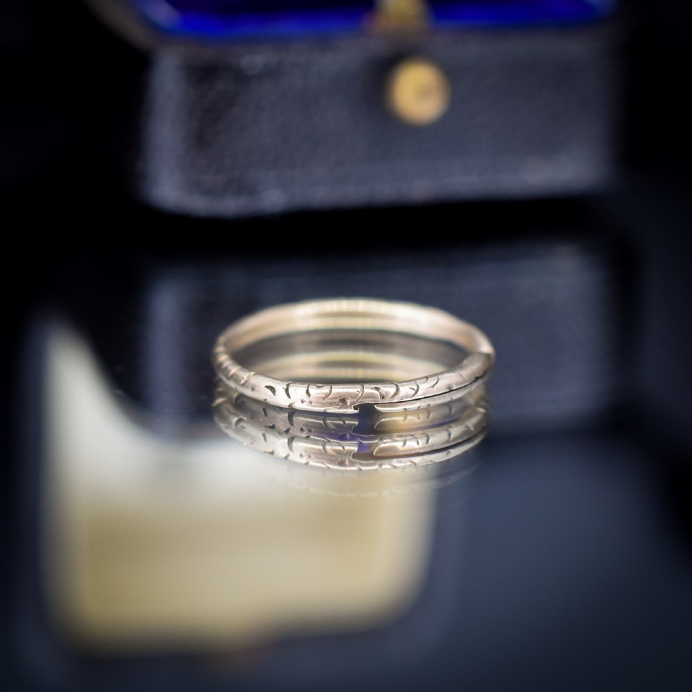 An antique 9ct yellow gold split ring measuring 17mm with hand-engraved notch details around the outer circumference. View V