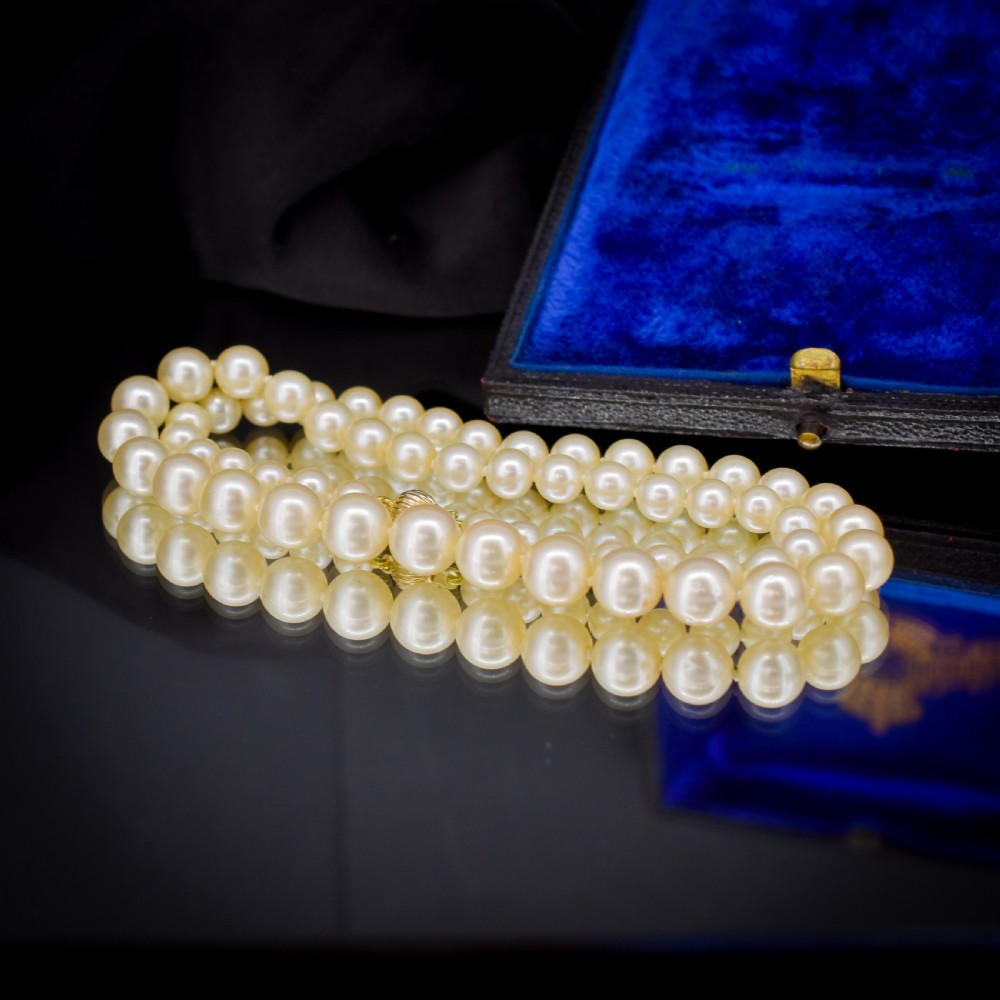 A graduated strand of cream pearls featuring a yellow gold fluted clasp. View VI