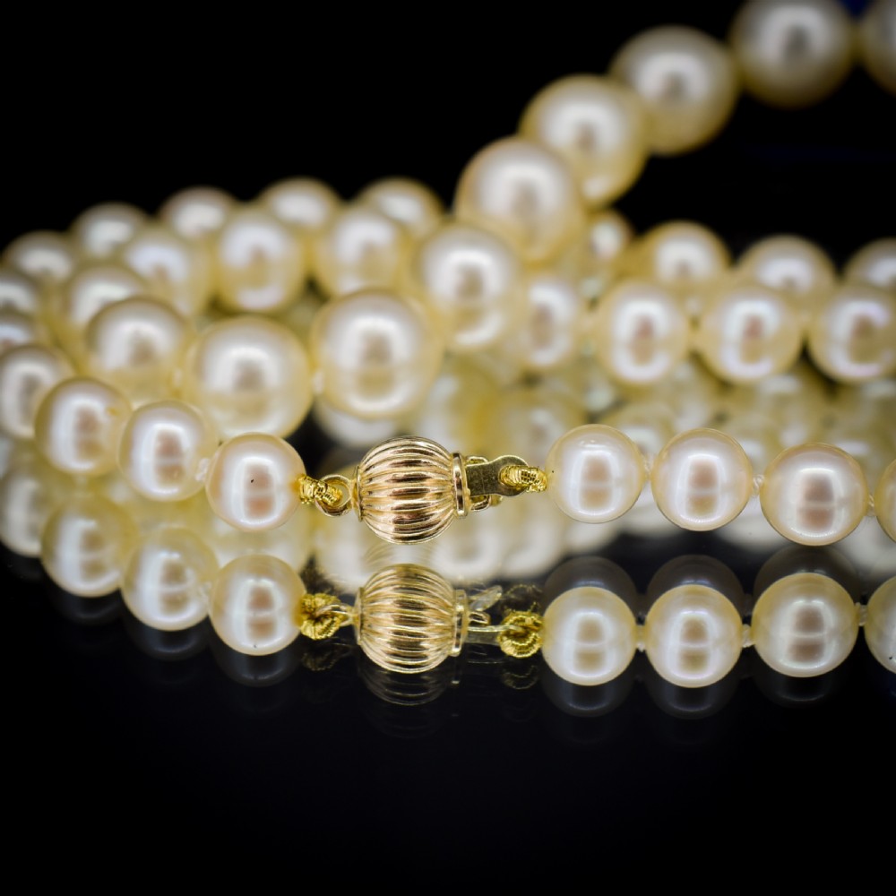 A graduated strand of cream pearls featuring a yellow gold fluted clasp. View VII