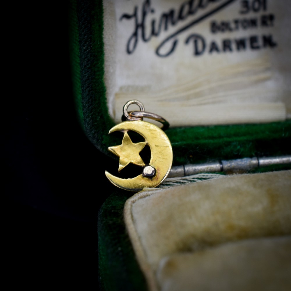 An 18ct gold crescent moon pendant set with seed pearls enclosing a star motif. View III
