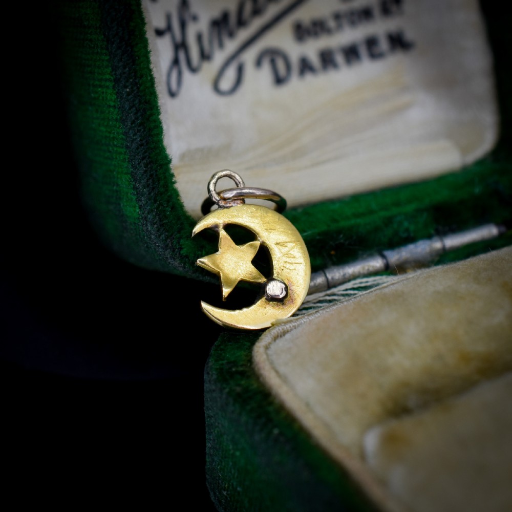 An 18ct gold crescent moon pendant set with seed pearls enclosing a star motif. View IV