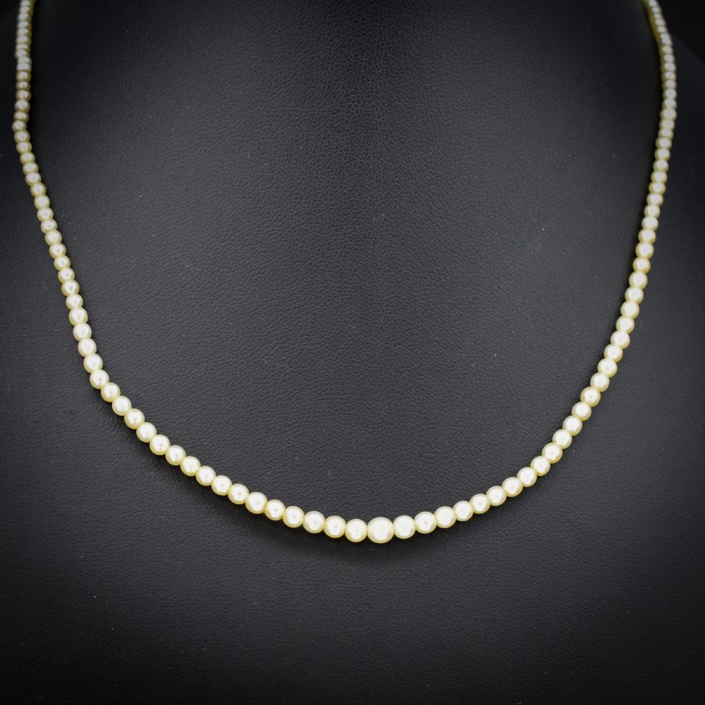 A single strand of graduated cream pearls fitted with an 18ct white gold clasp set with diamonds. View II