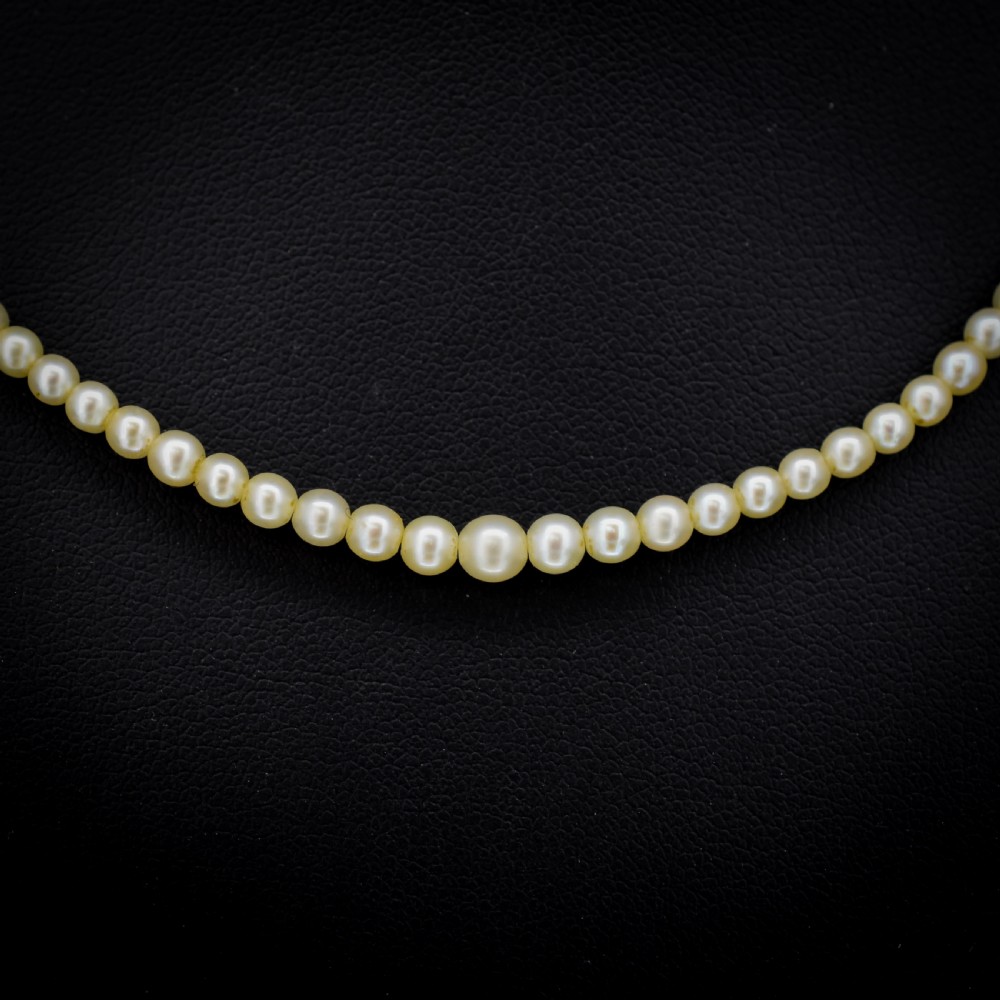 A single strand of graduated cream pearls fitted with an 18ct white gold clasp set with diamonds. View III