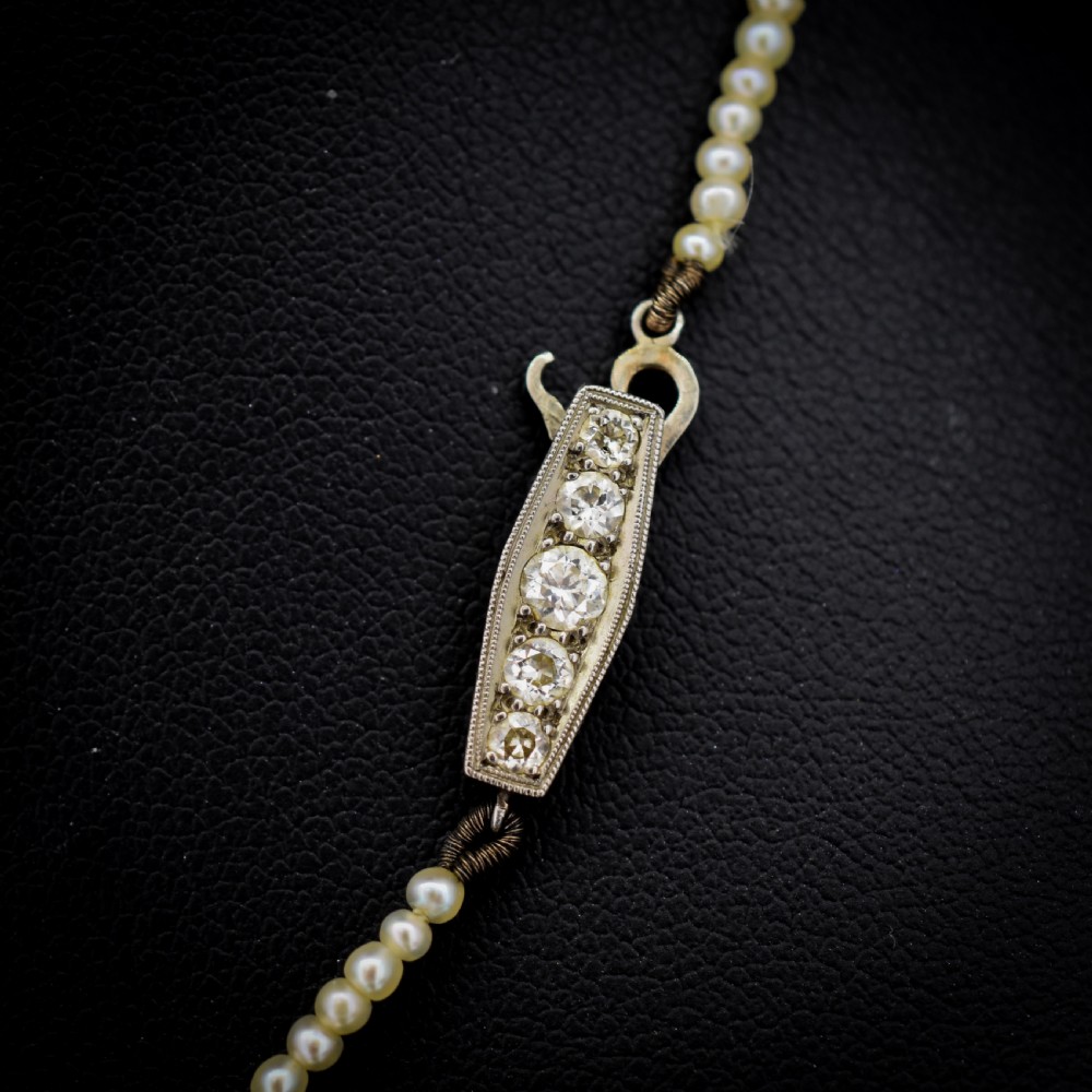 A single strand of graduated cream pearls fitted with an 18ct white gold clasp set with diamonds. View V