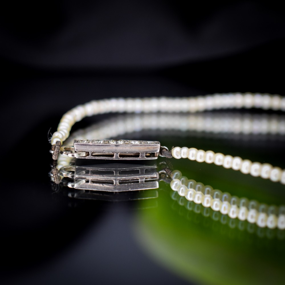 A single strand of graduated cream pearls fitted with an 18ct white gold clasp set with diamonds. View VII