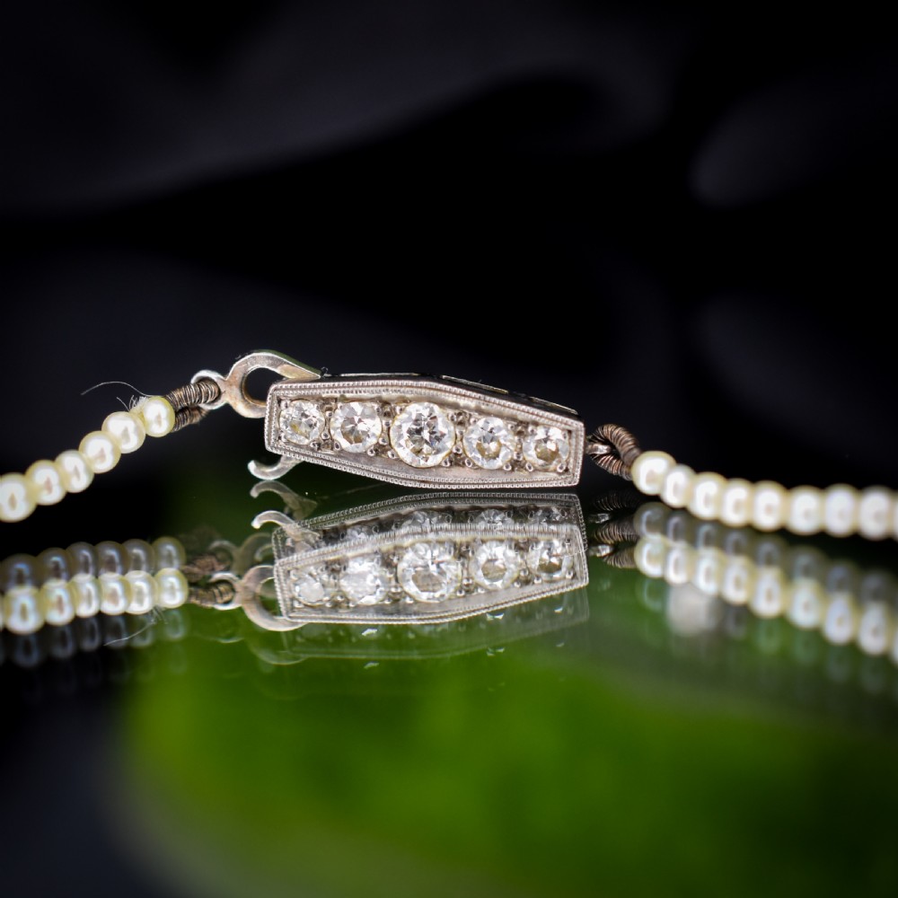 A single strand of graduated cream pearls fitted with an 18ct white gold clasp set with diamonds. View IX