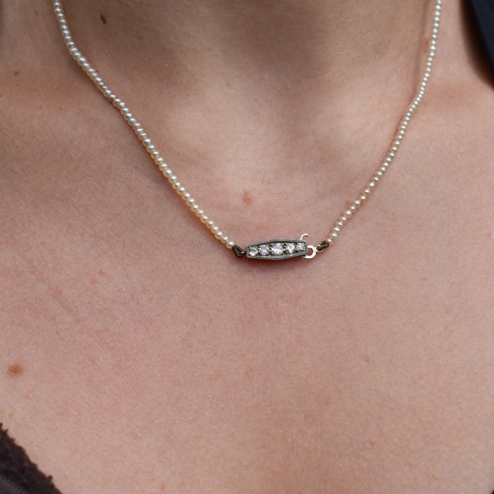 A single strand of graduated cream pearls fitted with an 18ct white gold clasp set with diamonds. View XII