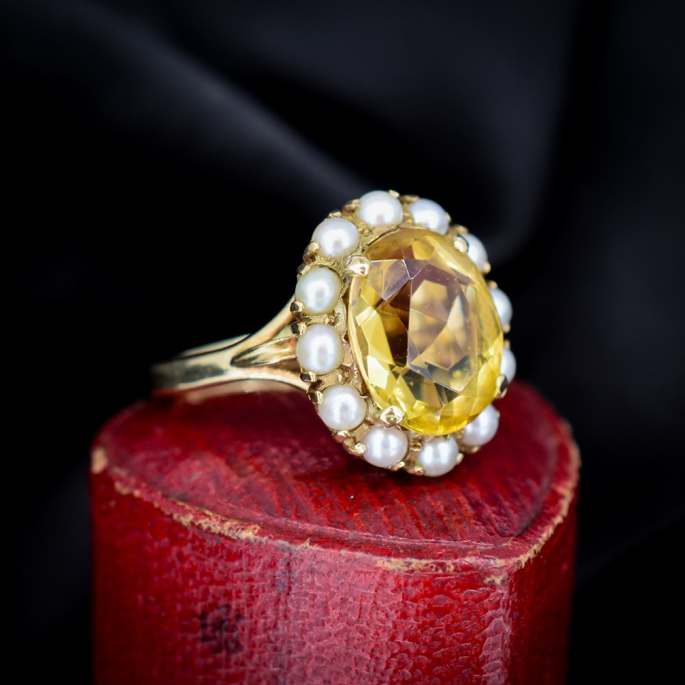 A vintage 9ct gold ring featuring a central oval faceted yellow citrine gemstone surrounded by a halo of small white pearls. View III