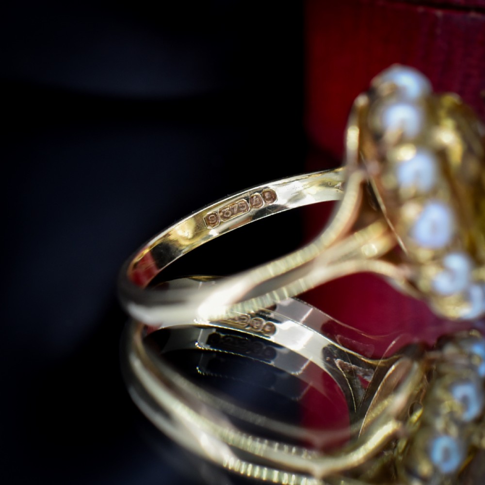 A vintage 9ct gold ring featuring a central oval faceted yellow citrine gemstone surrounded by a halo of small white pearls. View VII