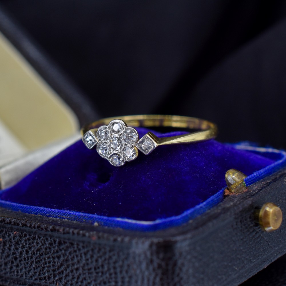 An Edwardian cluster ring crafted in yellow gold and platinum, featuring a central round diamond surrounded by a halo of diamonds with diamond-set shoulders. View III