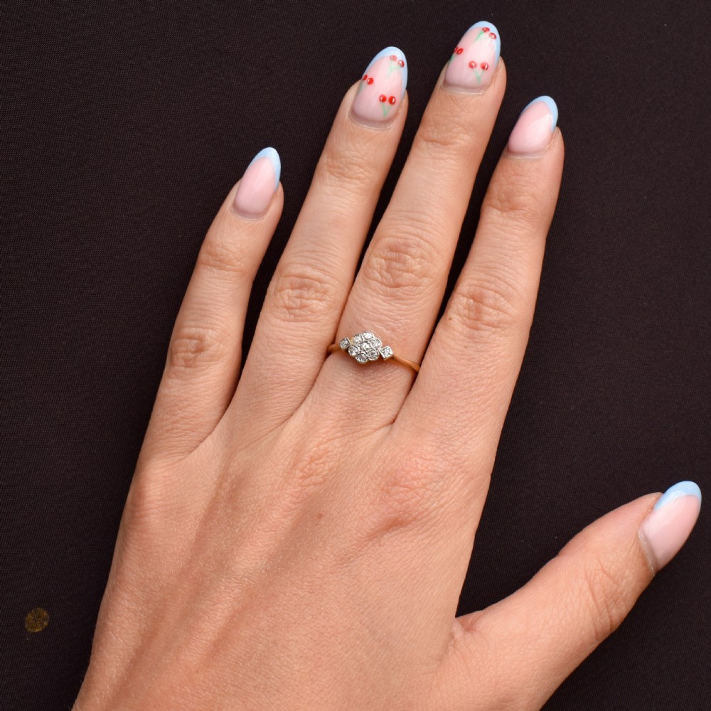 An Edwardian cluster ring crafted in yellow gold and platinum, featuring a central round diamond surrounded by a halo of diamonds with diamond-set shoulders. View IX
