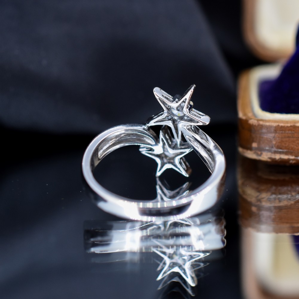 An 18ct white gold bypass ring featuring two star motifs set with brilliant-cut and baguette diamonds. View V