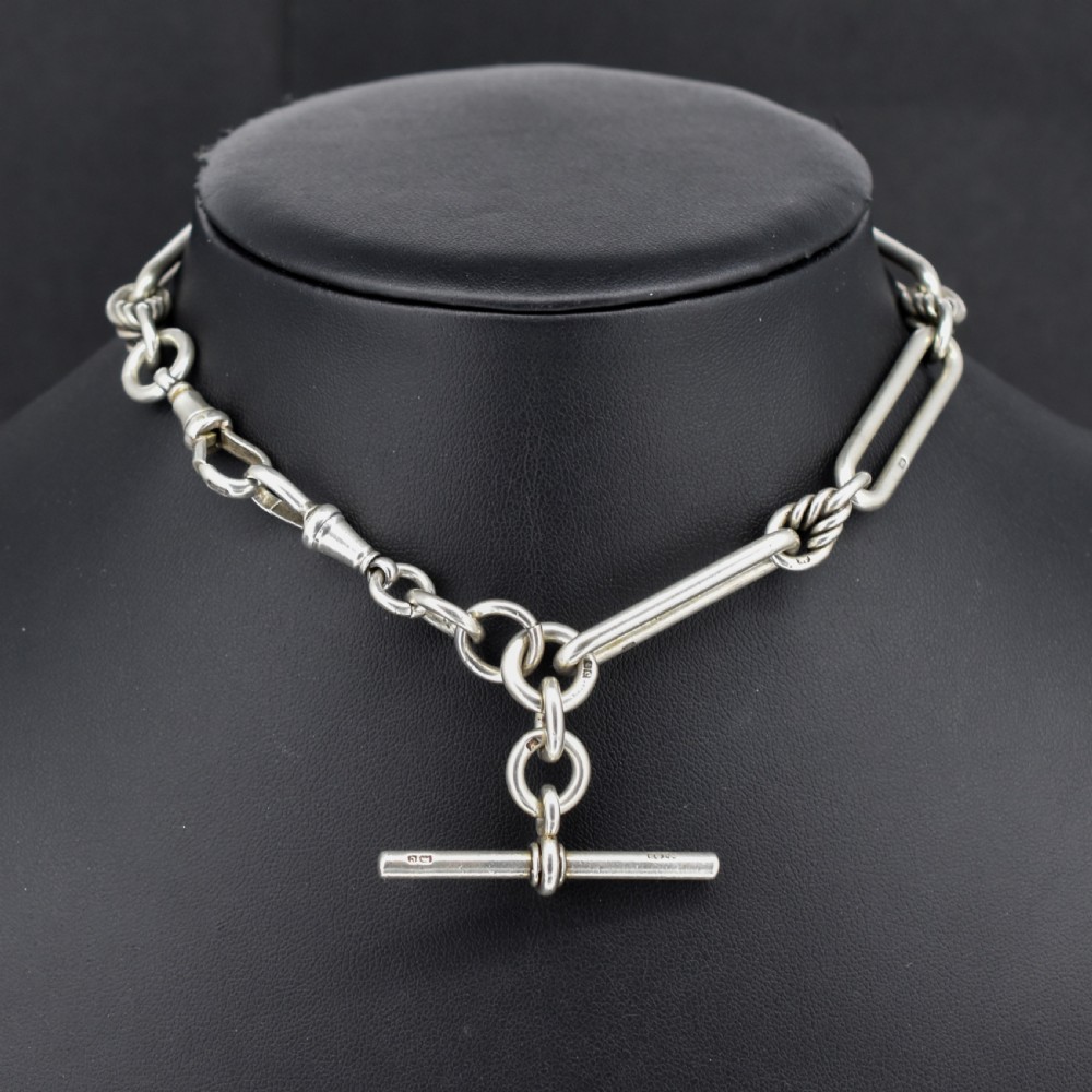 An antique sterling silver Albert watch chain featuring elongated trombone links interleaved with twisted love knots, complete with a T-bar and swivel clip. View II