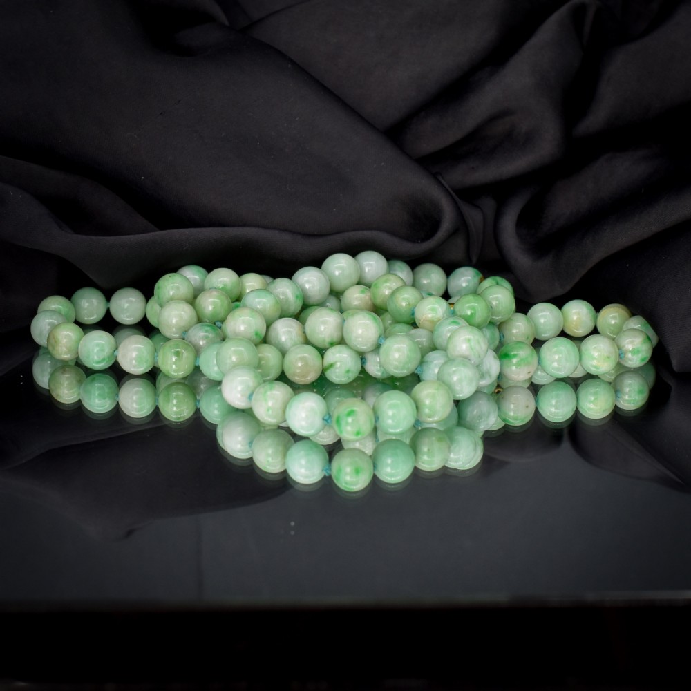 A double-strand necklace made of light green polished jade beads joined by a detailed gold hand-shaped figa clasp. View VI
