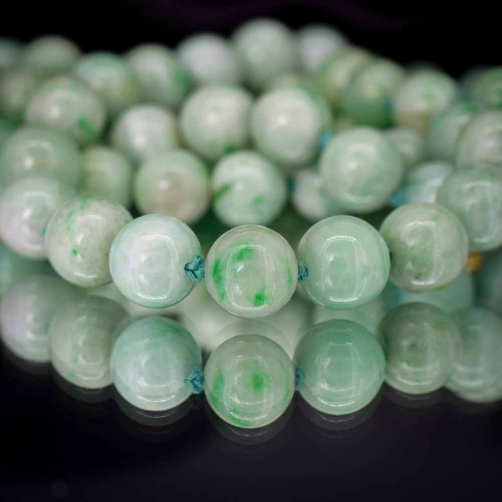 A double-strand necklace made of light green polished jade beads joined by a detailed gold hand-shaped figa clasp. View VII
