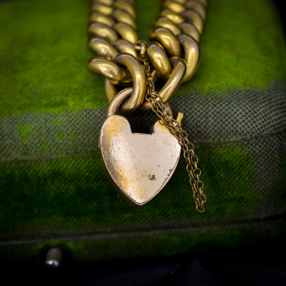 An antique rolled gold curb link bracelet featuring a heart-shaped padlock clasp and safety chain. View III