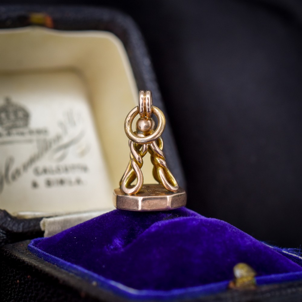 An antique 9ct yellow gold fob seal pendant featuring a looped wire handle design and a plain octagonal seal base. View II