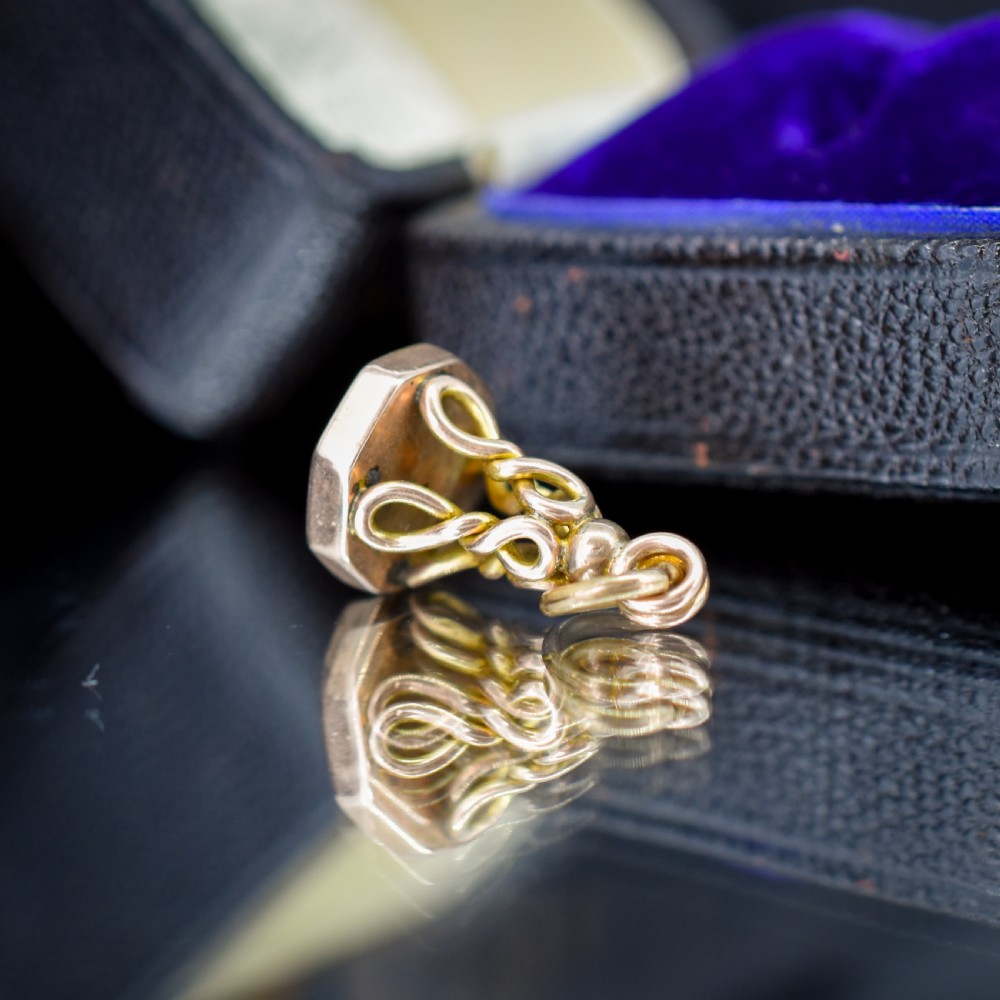 An antique 9ct yellow gold fob seal pendant featuring a looped wire handle design and a plain octagonal seal base. View VI