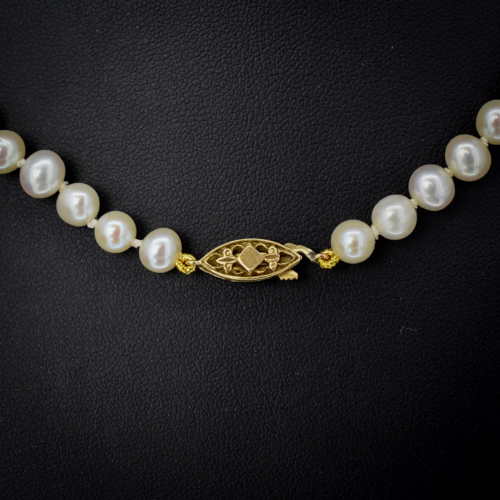 A single strand of graduated cream pearls fitted with a detailed yellow gold filigree clasp. View III