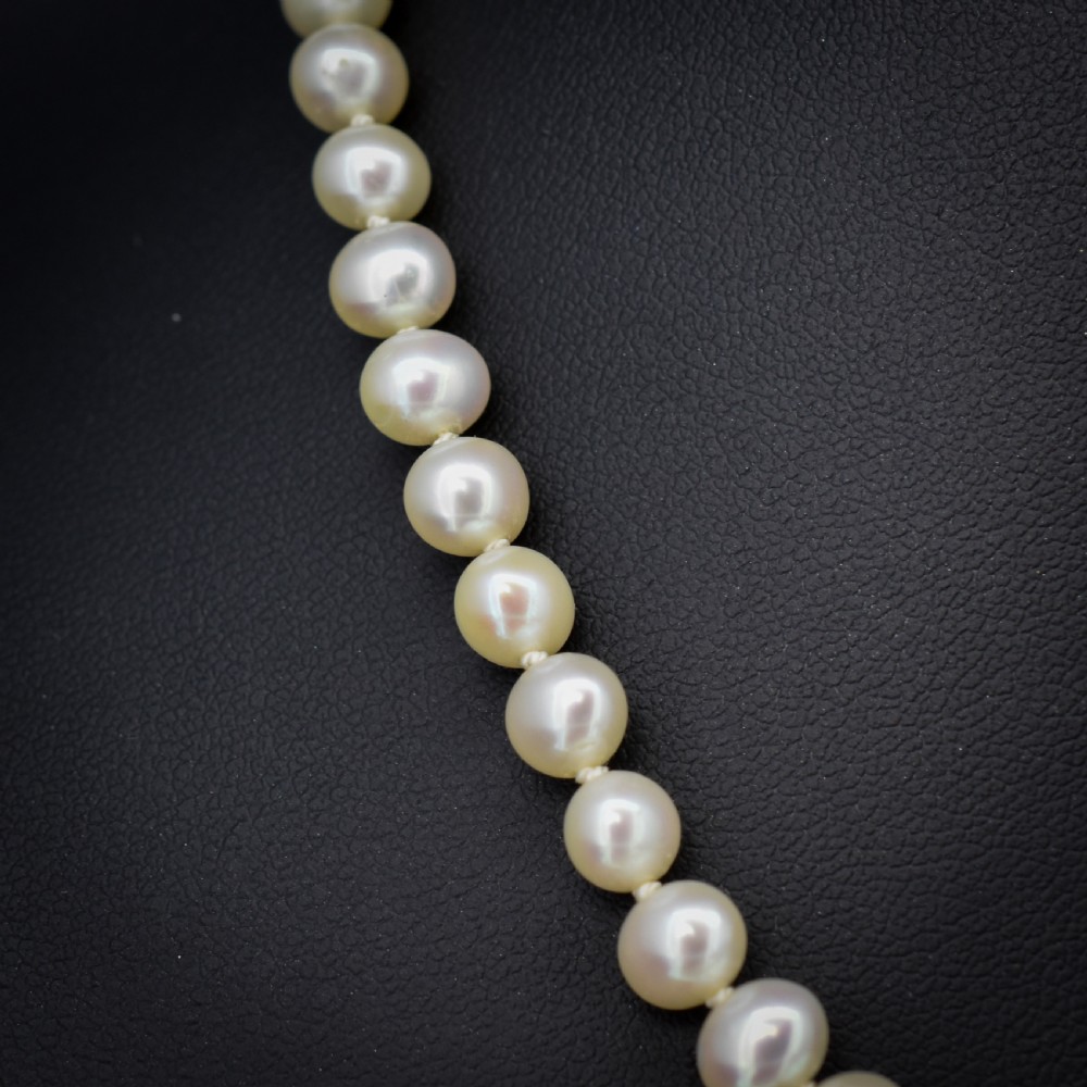 A single strand of graduated cream pearls fitted with a detailed yellow gold filigree clasp. View IV