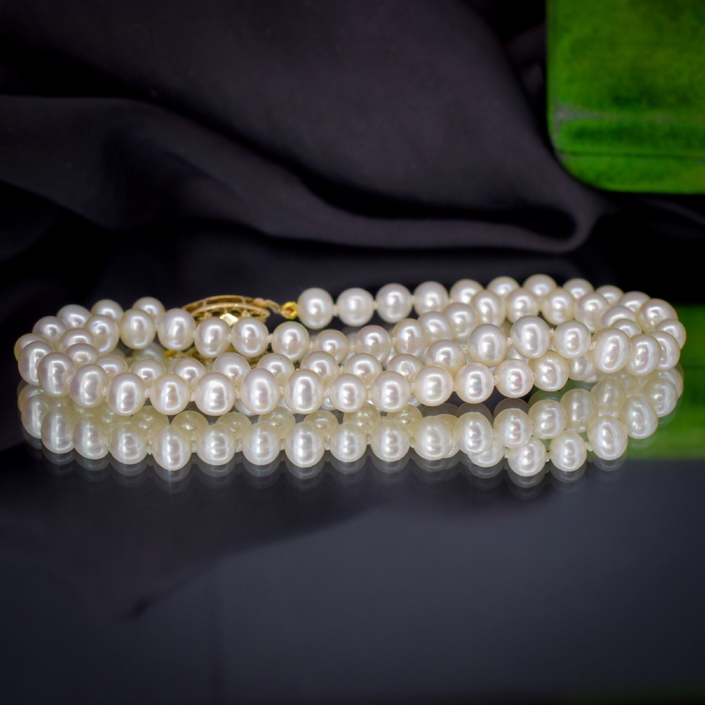 A single strand of graduated cream pearls fitted with a detailed yellow gold filigree clasp. View VI
