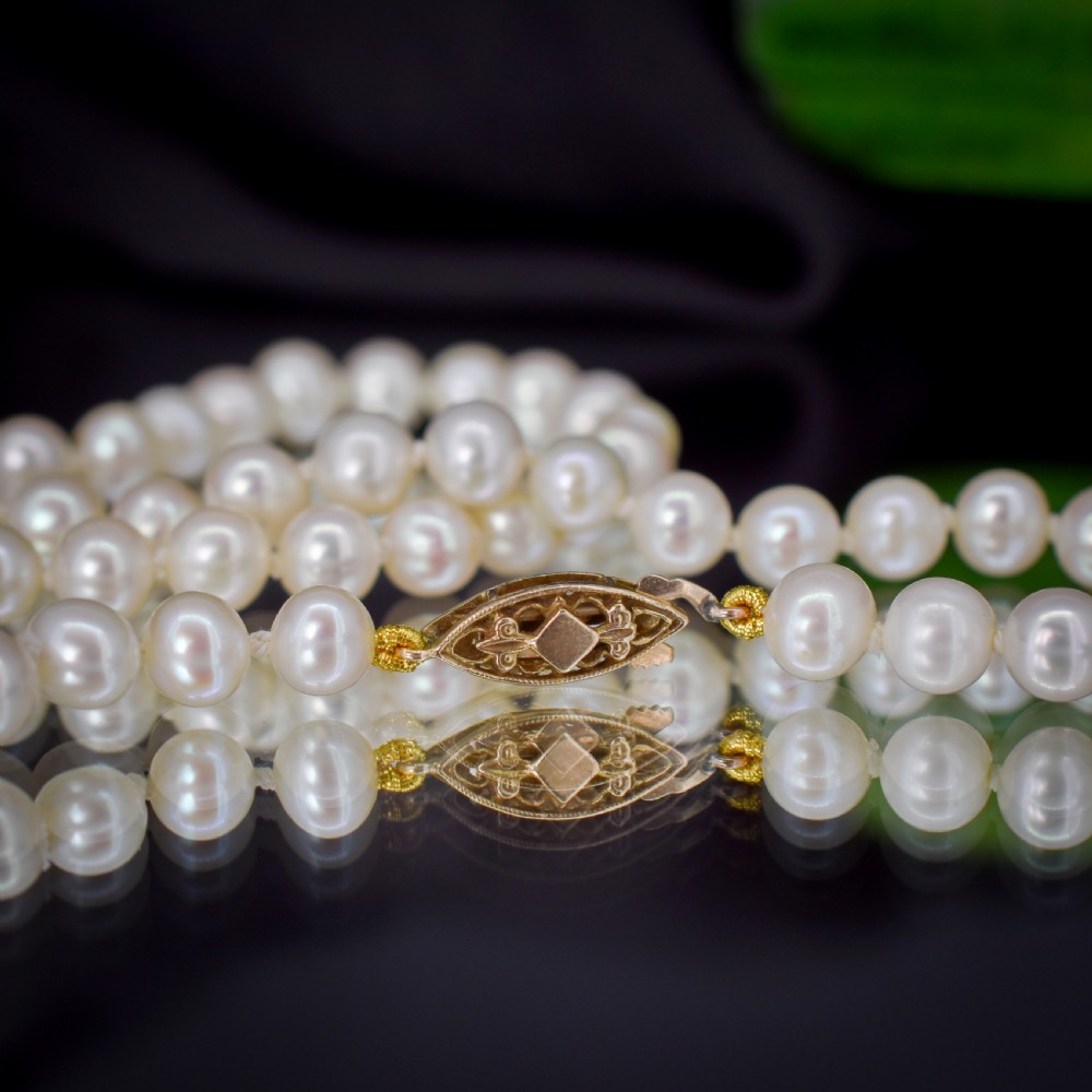 A single strand of graduated cream pearls fitted with a detailed yellow gold filigree clasp. View VII