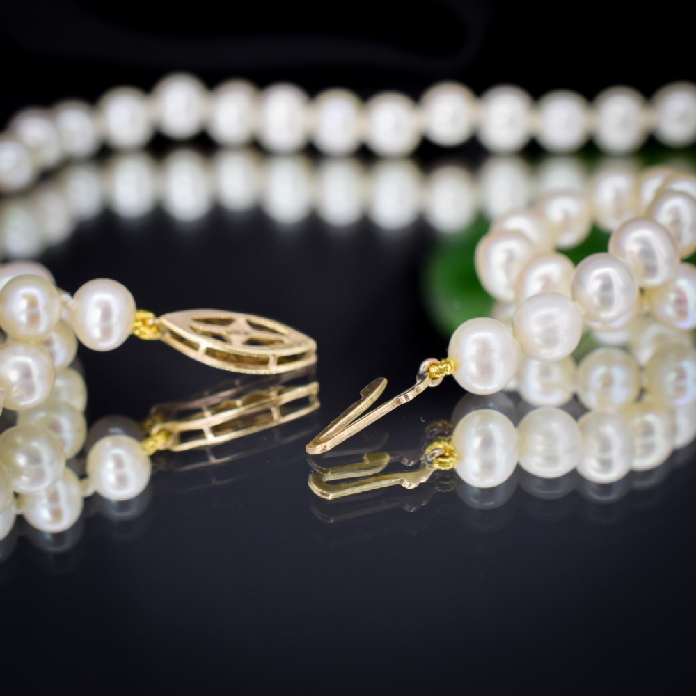 A single strand of graduated cream pearls fitted with a detailed yellow gold filigree clasp. View VIII
